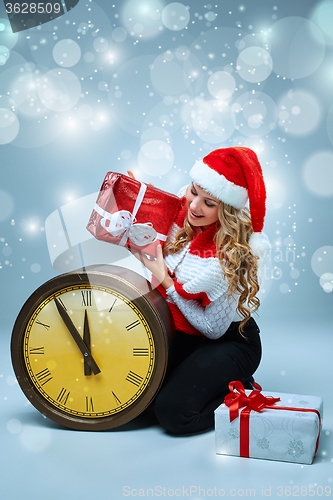 Image of Girl dressed in santa hat holding with a Christmas decorations  