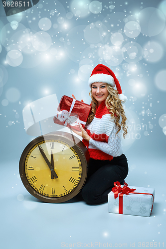 Image of Girl dressed in santa hat holding with a Christmas decorations  