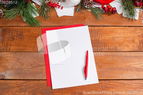 Image of The blank sheet of paper on the wooden table with a pen 