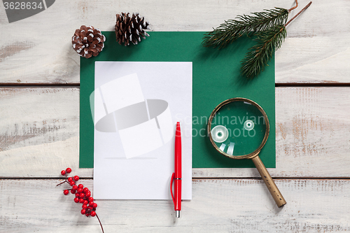 Image of The blank sheet of paper on the wooden table with a pen 