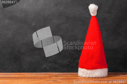 Image of The Santa red hat on wooden background