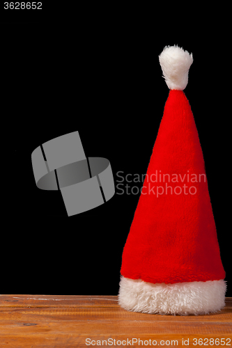 Image of The Santa red hat on wooden background