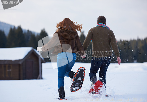 Image of couple having fun and walking in snow shoes