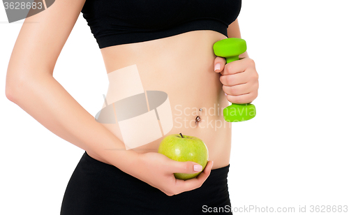 Image of Sporty girl holding weight and apple