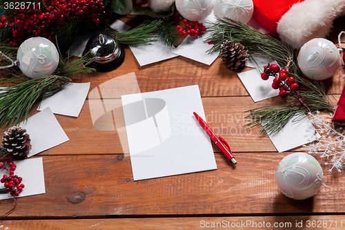 Image of The blank sheet of paper on the wooden table with a pen 