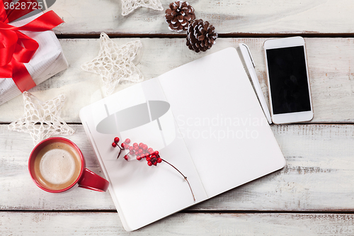 Image of The open notebook on the wooden table with a phone