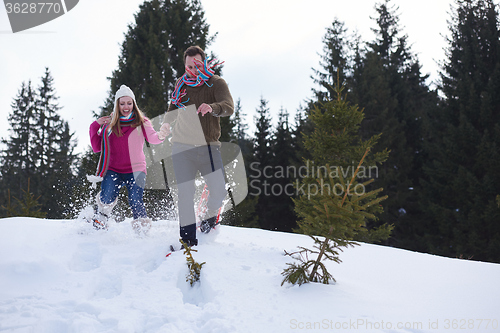 Image of couple having fun and walking in snow shoes