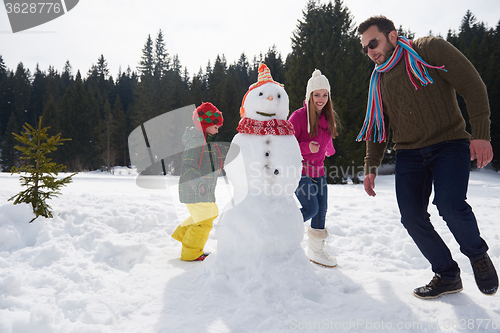 Image of happy family building snowman