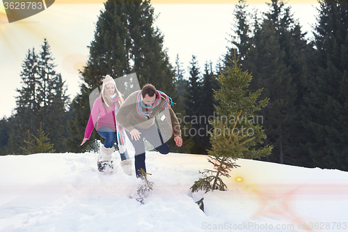 Image of couple having fun and walking in snow shoes