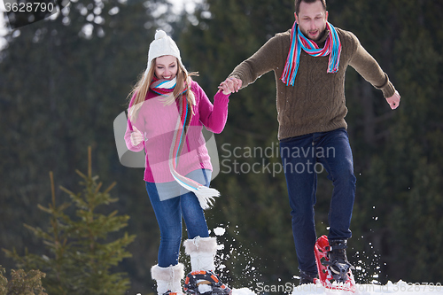 Image of couple having fun and walking in snow shoes