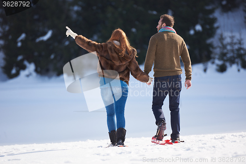 Image of couple having fun and walking in snow shoes