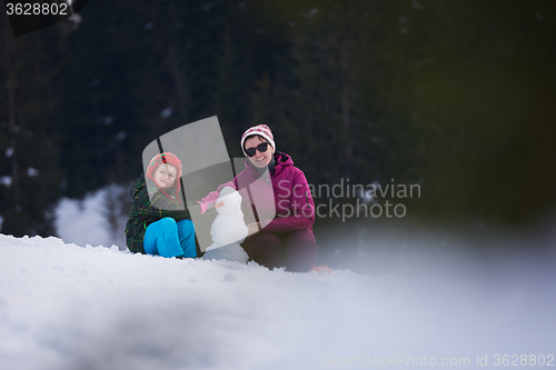 Image of happy family building snowman