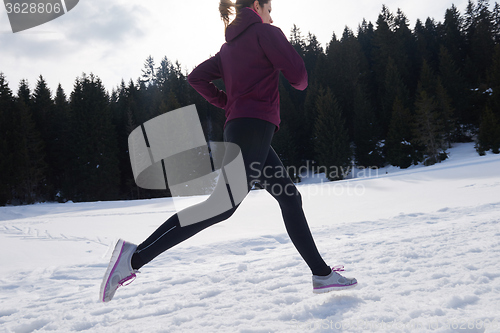 Image of yougn woman jogging outdoor on snow in forest