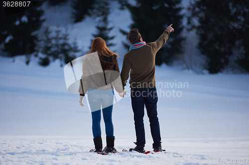 Image of couple having fun and walking in snow shoes