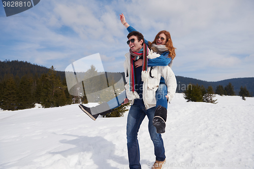 Image of happy young couple having fun on fresh show on winter vacation