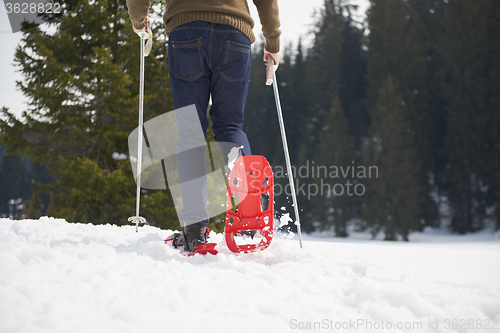 Image of couple having fun and walking in snow shoes