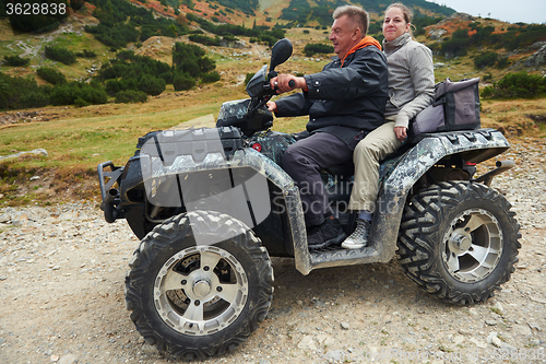 Image of couple drive atv quad bike