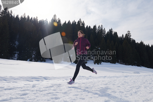 Image of yougn woman jogging outdoor on snow in forest