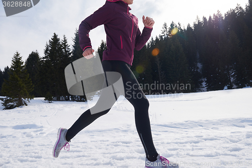 Image of yougn woman jogging outdoor on snow in forest