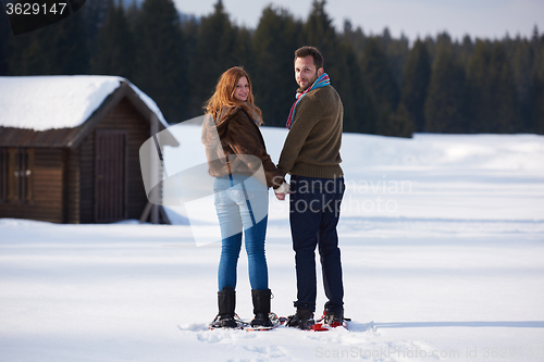 Image of couple having fun and walking in snow shoes