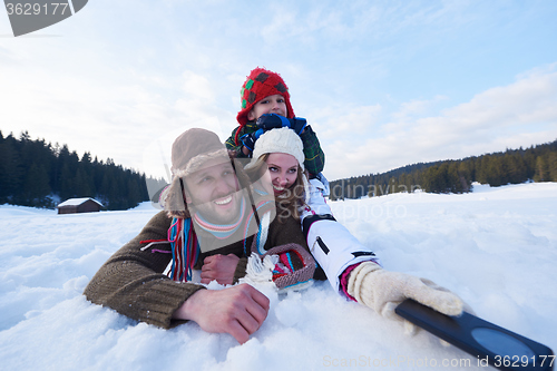 Image of romantic couple have fun in fresh snow and taking selfie