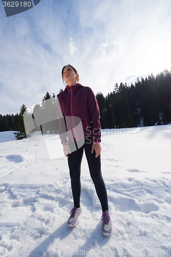 Image of yougn woman jogging outdoor on snow in forest