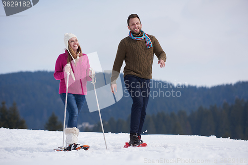 Image of couple having fun and walking in snow shoes