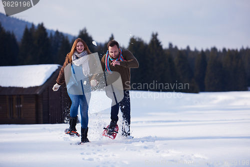 Image of couple having fun and walking in snow shoes