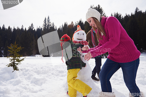 Image of happy family building snowman