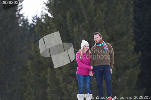 Image of couple having fun and walking in snow shoes