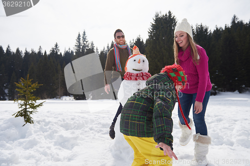 Image of happy family building snowman