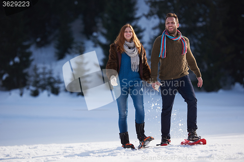 Image of couple having fun and walking in snow shoes