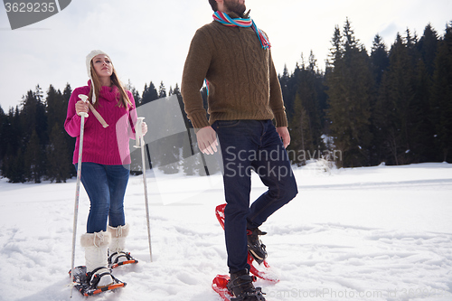 Image of couple having fun and walking in snow shoes