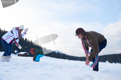 Image of happy family playing together in snow at winter