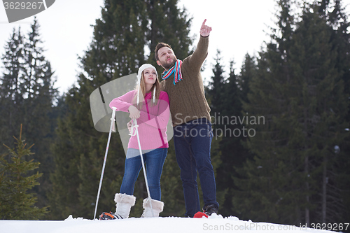 Image of couple having fun and walking in snow shoes