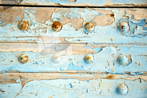 Image of dirty stripped paint in  blue wood door   rusty nail