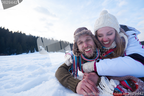 Image of couple having fun and walking in snow shoes