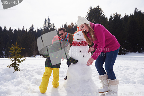 Image of happy family building snowman