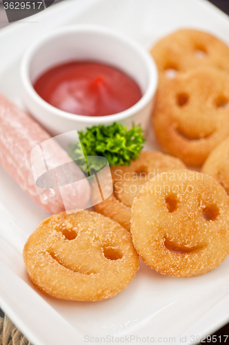 Image of sausages with smiling potatoes