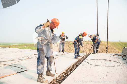 Image of Builders with metal crow bar installing concrete panel