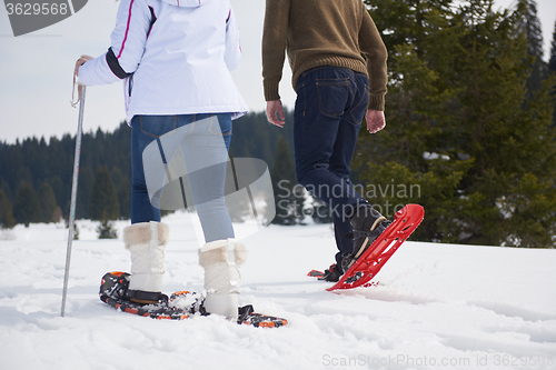Image of couple having fun and walking in snow shoes