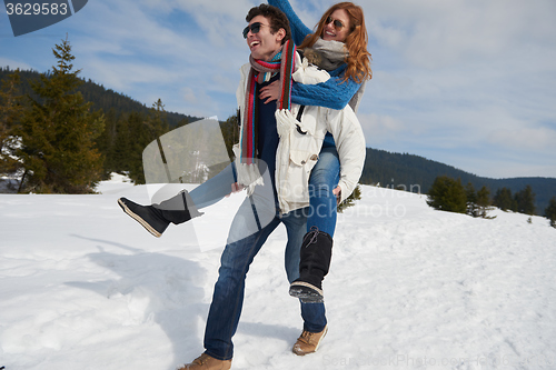 Image of happy young couple having fun on fresh show on winter vacation