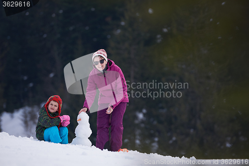 Image of happy family building snowman