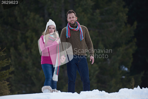 Image of couple having fun and walking in snow shoes