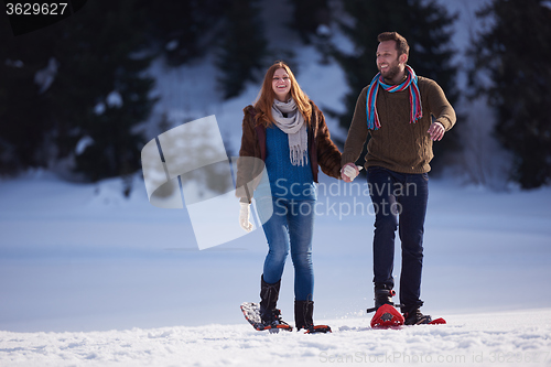 Image of couple having fun and walking in snow shoes