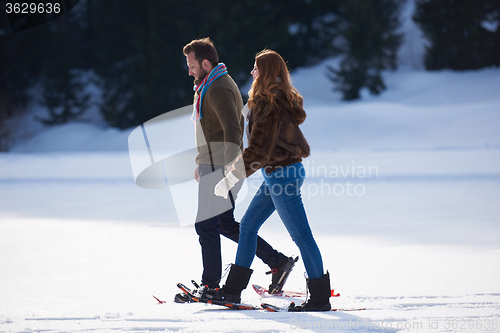 Image of couple having fun and walking in snow shoes