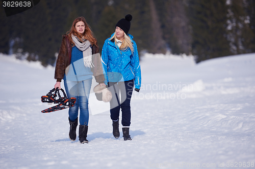 Image of couple having fun and walking in snow shoes