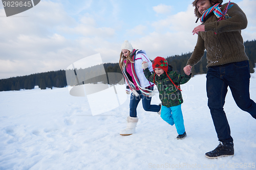 Image of happy family playing together in snow at winter