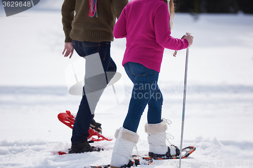 Image of couple having fun and walking in snow shoes