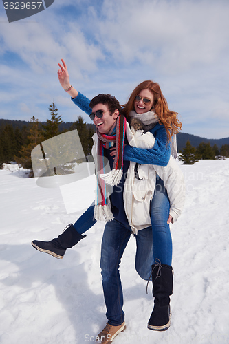 Image of happy young couple having fun on fresh show on winter vacation